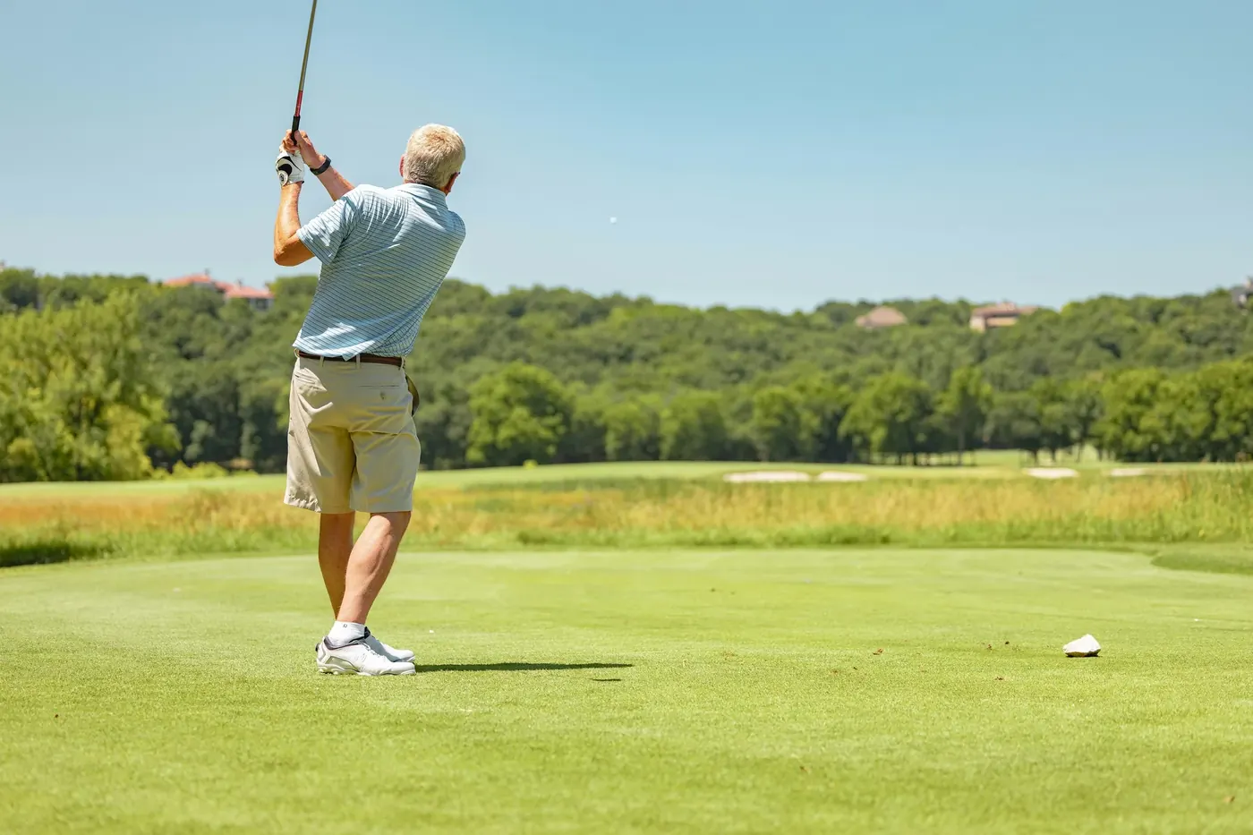 Golf instructor's student driving a ball on the range
